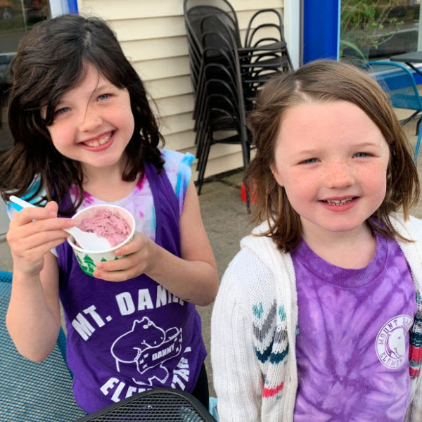 Two young girls enjoying purple ice cream