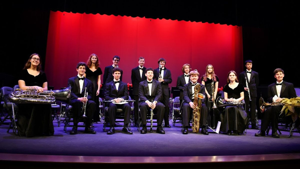 MHS Musicians holding instruments sitting on a stage
