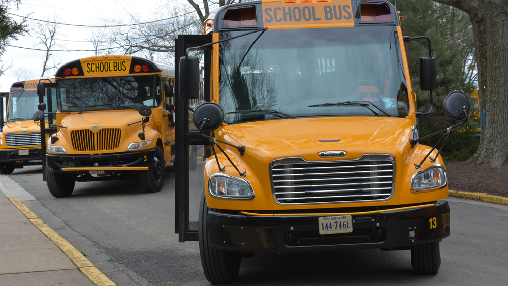 Three School Buses waiting for school to dismiss