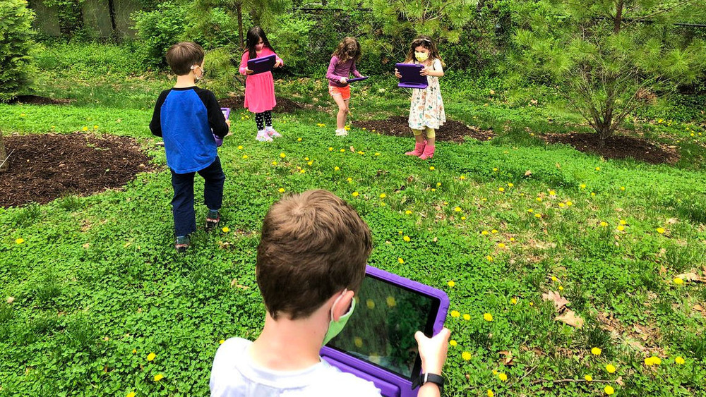 Students taking pictures of flowers with iPads