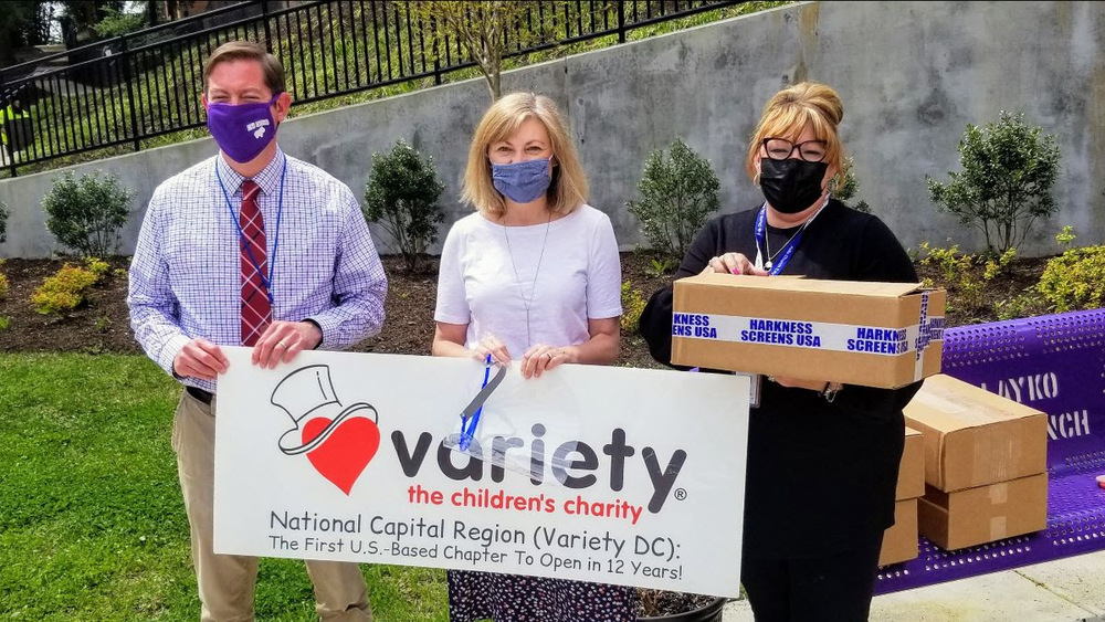 Principal Tim Kasik and Special Education director Rebecca Sharp pose with donated face shields from Variety DC Executive Director Leigh Burke