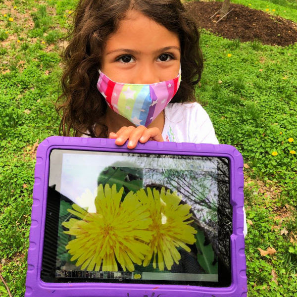 Girl shows a picture of a flower she took with her iPad